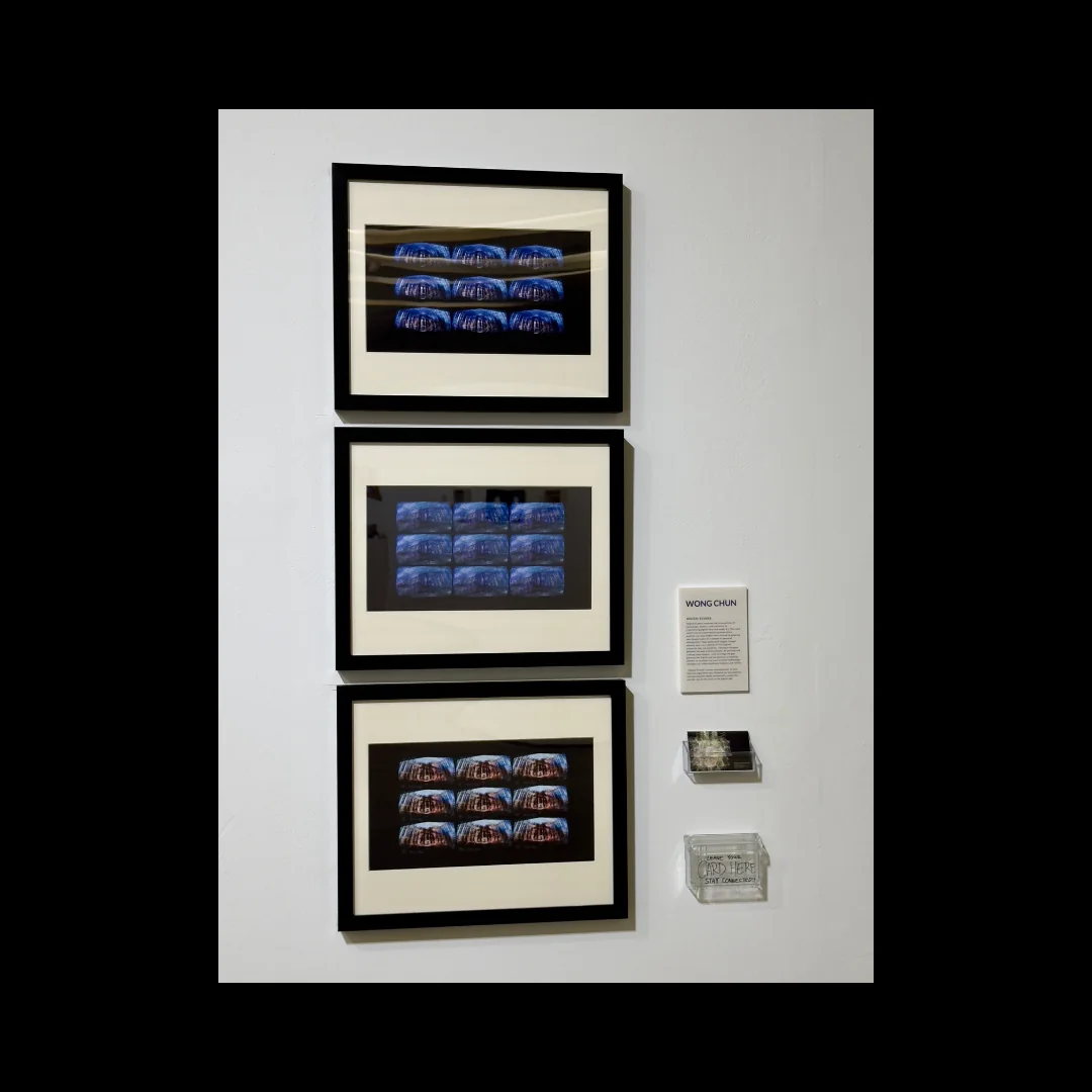 Three framed blue photographic works installed vertically on a gallery wall.